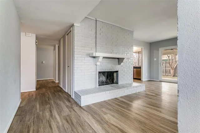 a view of a livingroom with wooden floor and a fireplace