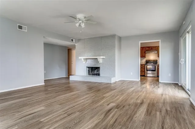 a view of an empty room with a fireplace and a window