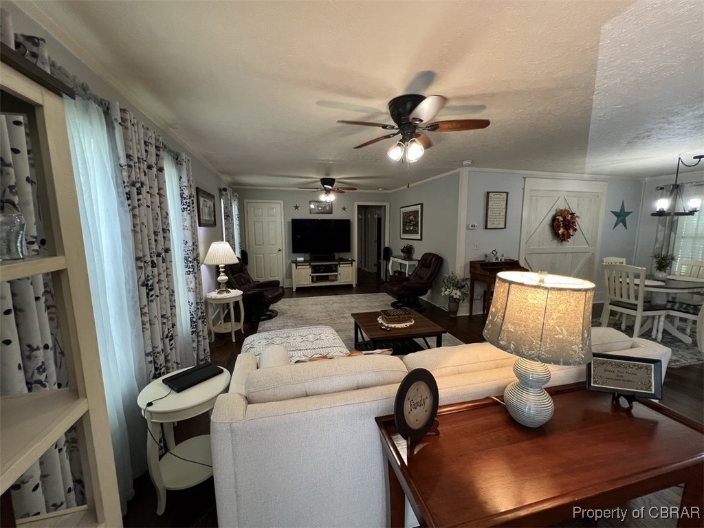 102 Mechams Cove Road Topping, VA 23169 - Photo 23 of 40 Living area featuring a ceiling fan and a chandelier