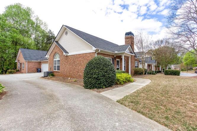 3402 Raes Creek Road, Unit 27 Marietta, GA 30008 - Photo 5 of 32 a front view of a house with a yard and garage