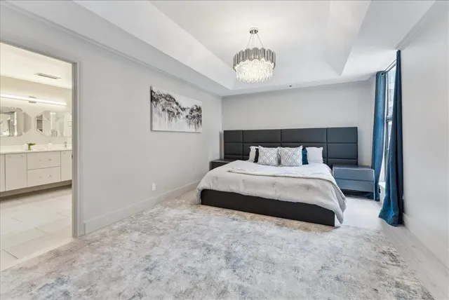 a bedroom with a large bed and a chandelier