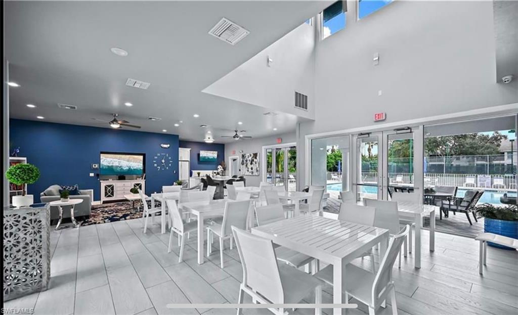 3745 Fieldstone Boulevard, Unit 107 Naples, FL 34109 - Photo 11 of 14 a view of a dining room with furniture wooden floor and chandelier