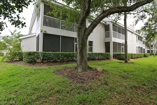 a view of a house with yard and a tree