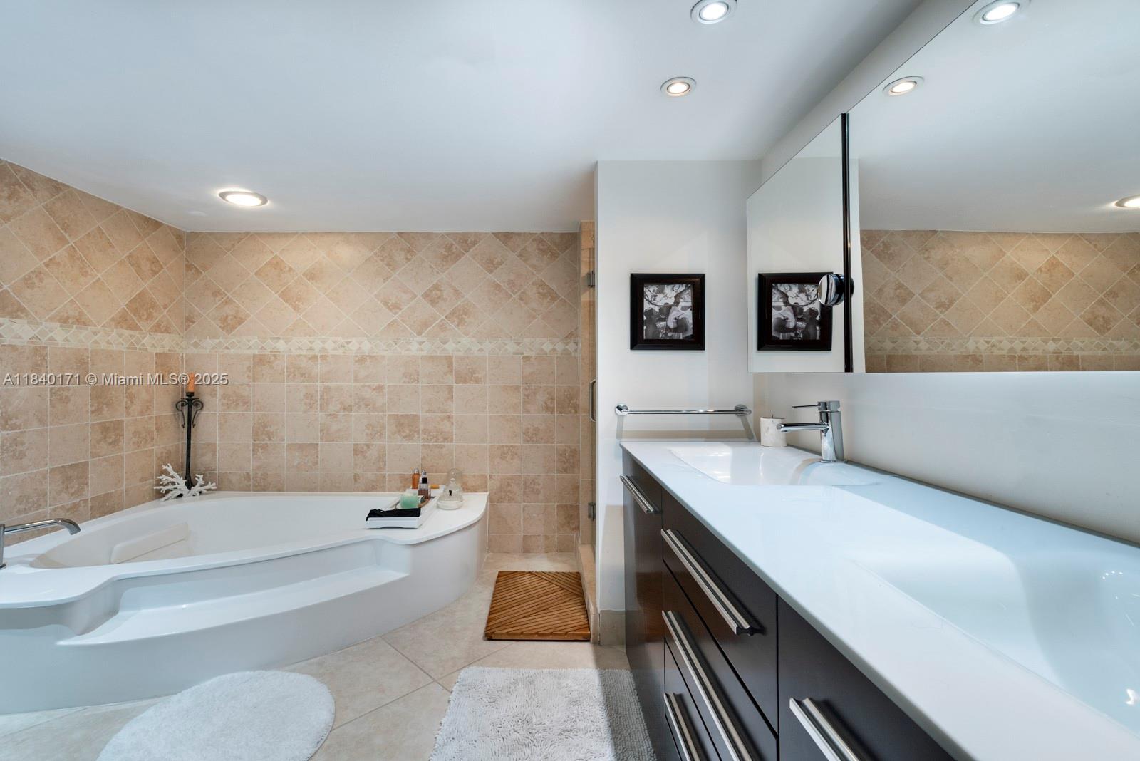 4000 Towerside Terrace, Unit 1005 Miami, FL 33138 - Photo 9 of 25 a bathroom with a granite countertop sink a toilet a mirror and bathtub