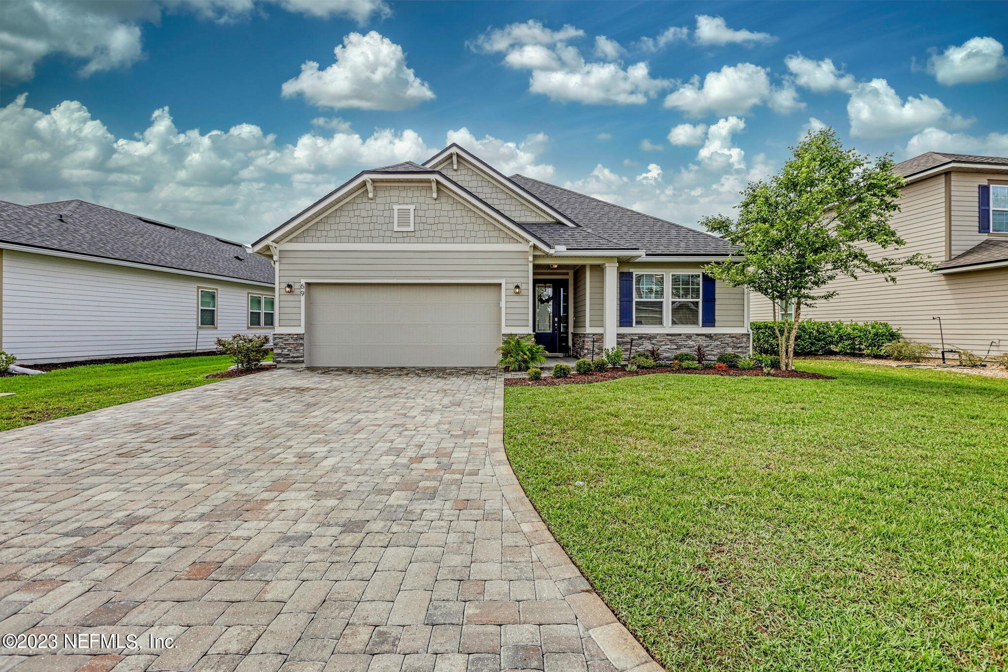 a front view of a house with a garden and yard