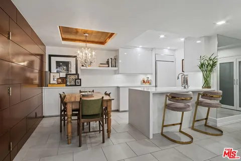 a kitchen with a dining table chairs and refrigerator