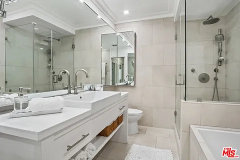 a bathroom with a double vanity sink toilet mirror and shower