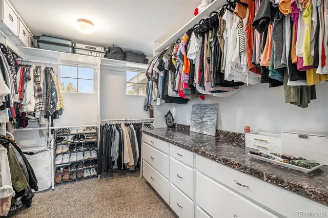 a view of walk in closet with clothes and shoes