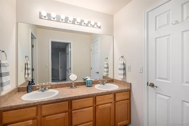 a bathroom with a double vanity sink and a mirror
