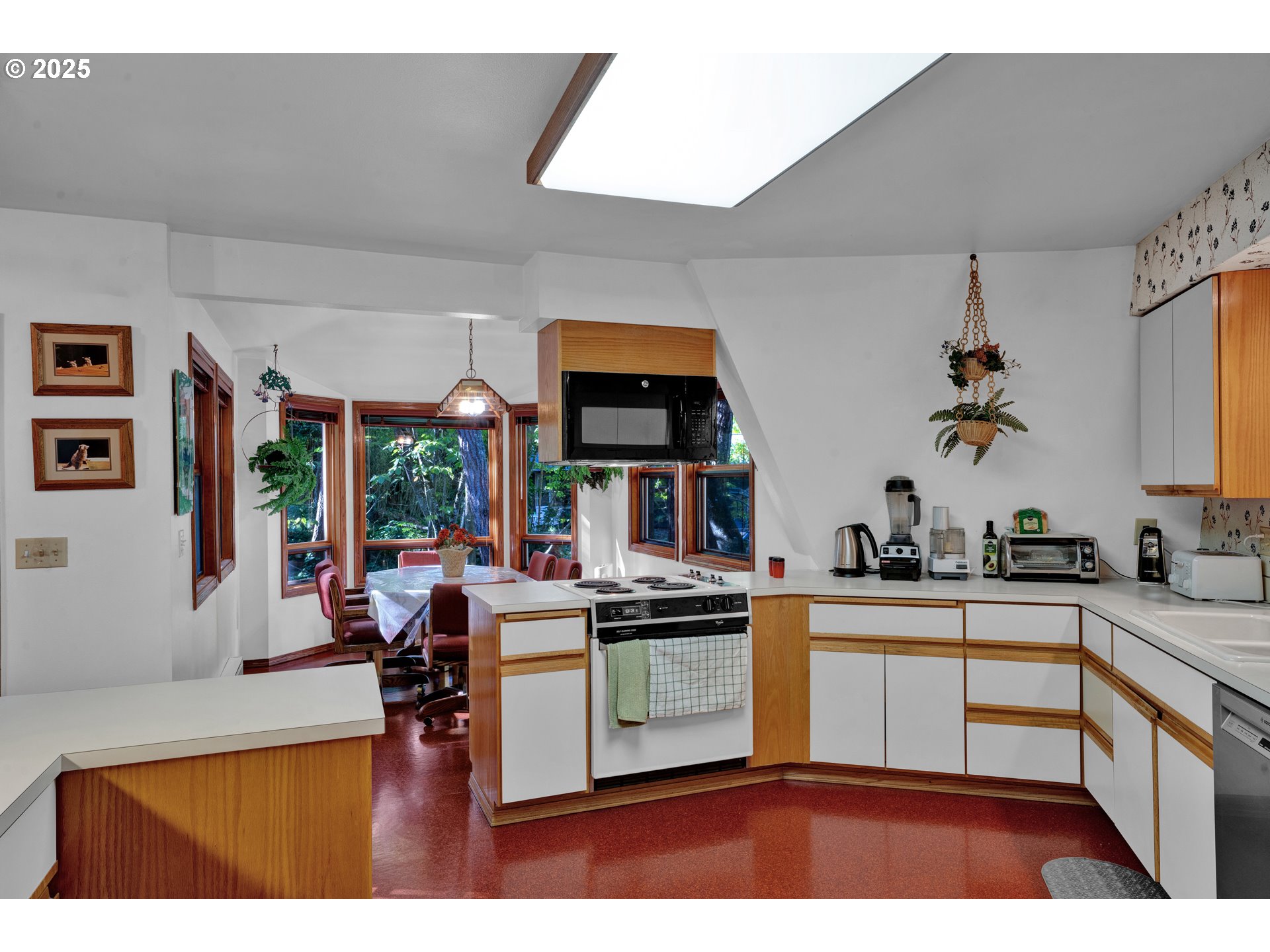 434 East 39th Avenue Eugene, OR 97405 - Photo 10 of 48 a kitchen with stainless steel appliances granite countertop a stove a sink dishwasher and white cabinets with wooden floor