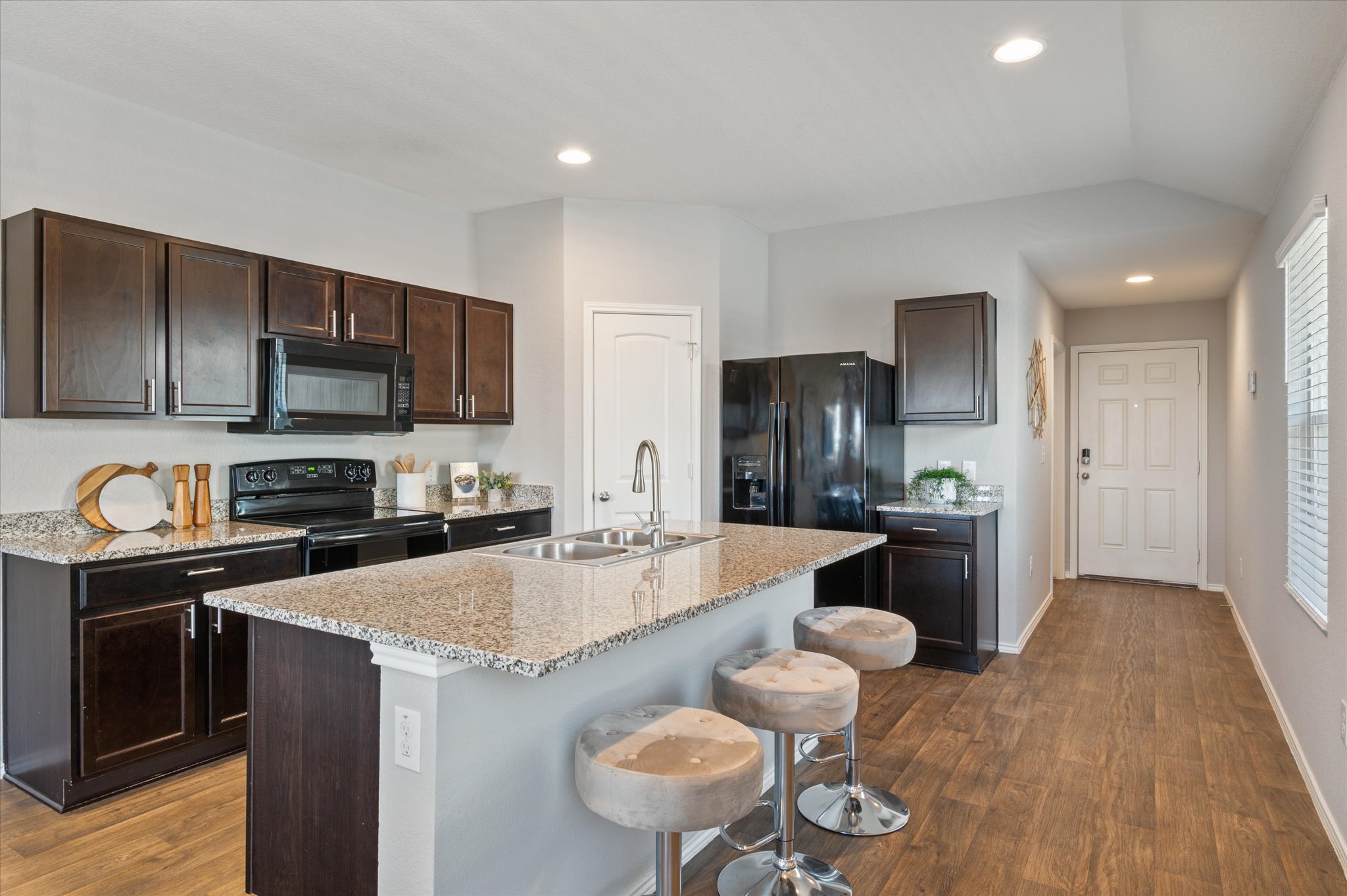 15003 Tuff Road Manor, TX 78653 - Photo 8 of 27 a large kitchen with a table chairs refrigerator and microwave