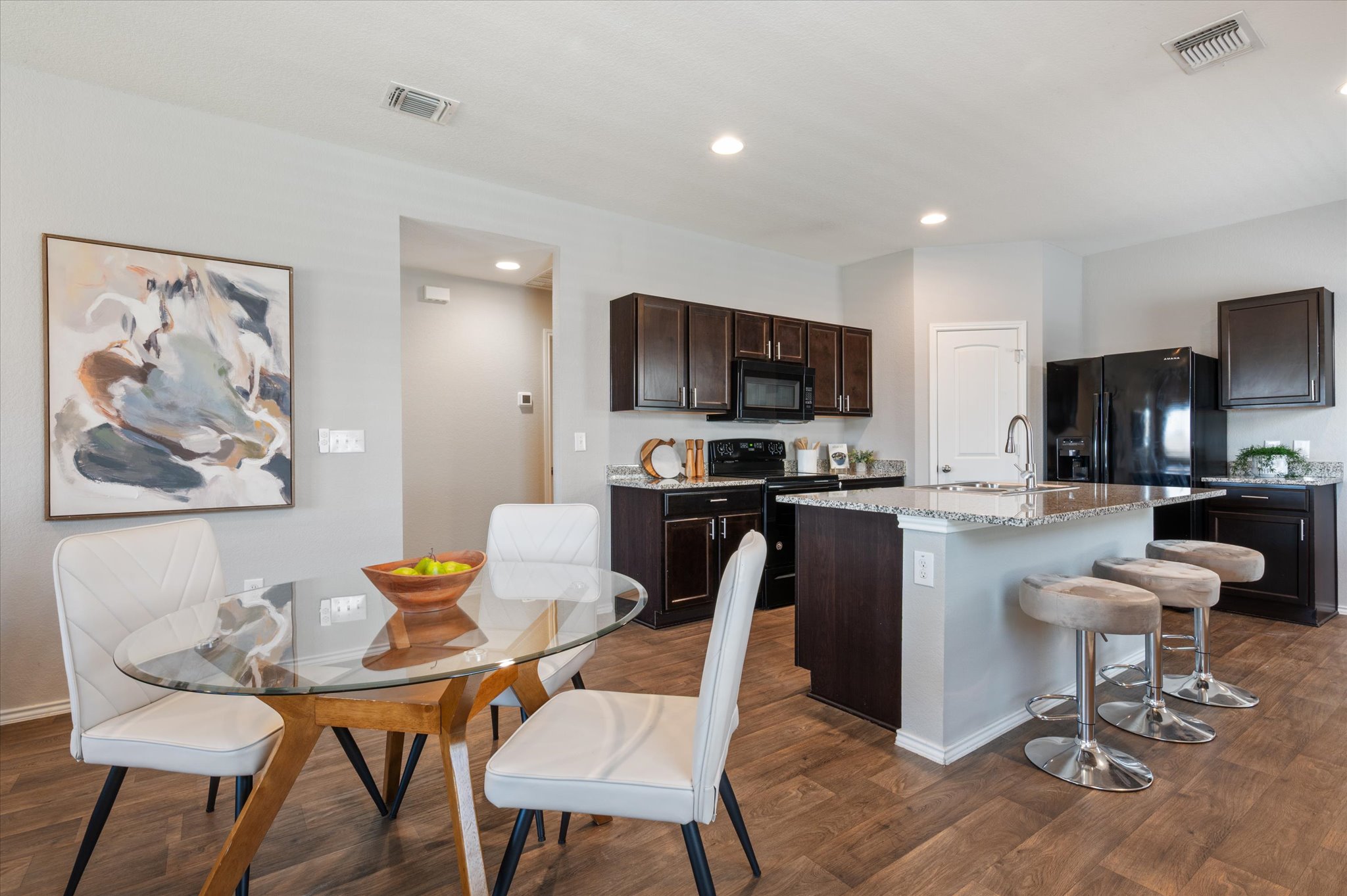 15003 Tuff Road Manor, TX 78653 - Photo 9 of 27 a kitchen with a dining table chairs and a refrigerator