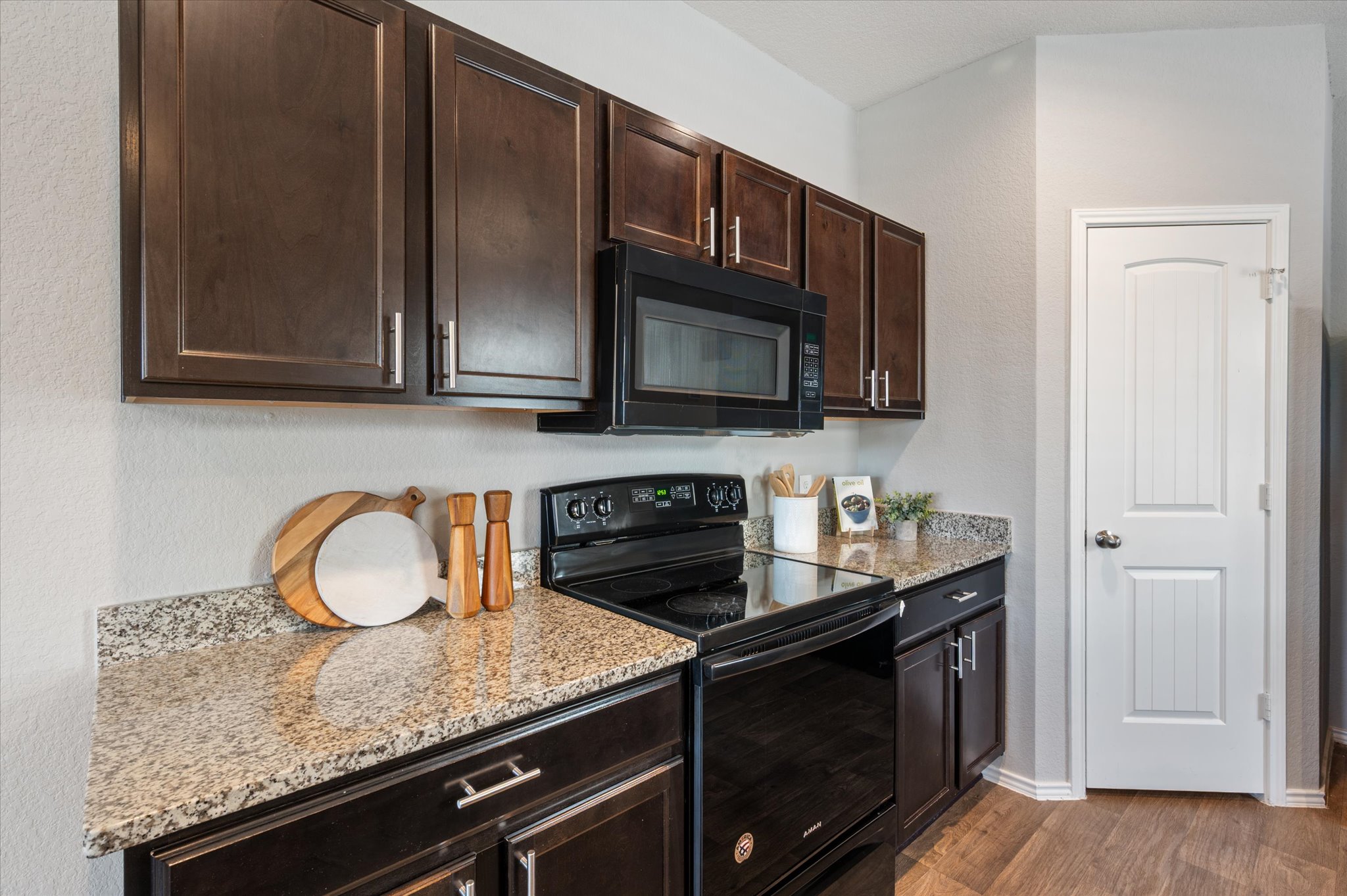 15003 Tuff Road Manor, TX 78653 - Photo 10 of 27 a kitchen with granite countertop wooden cabinets and a stove top oven