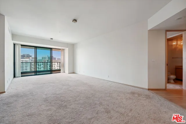 a view of a hallway with wooden floor and a bathroom