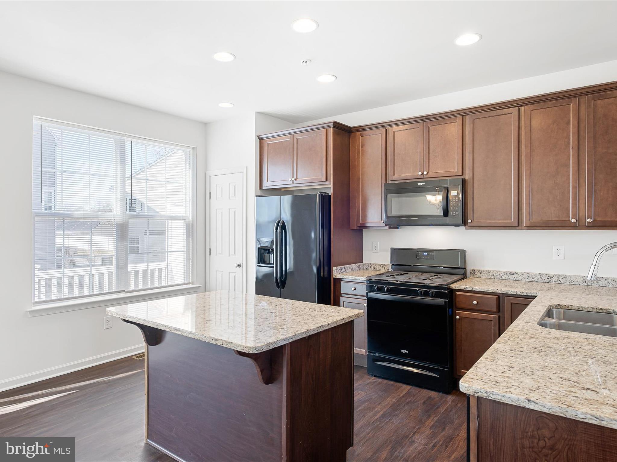 415 Lenape Way Claymont, DE 19703 - Photo 9 of 26 a kitchen with kitchen island a sink stove and refrigerator