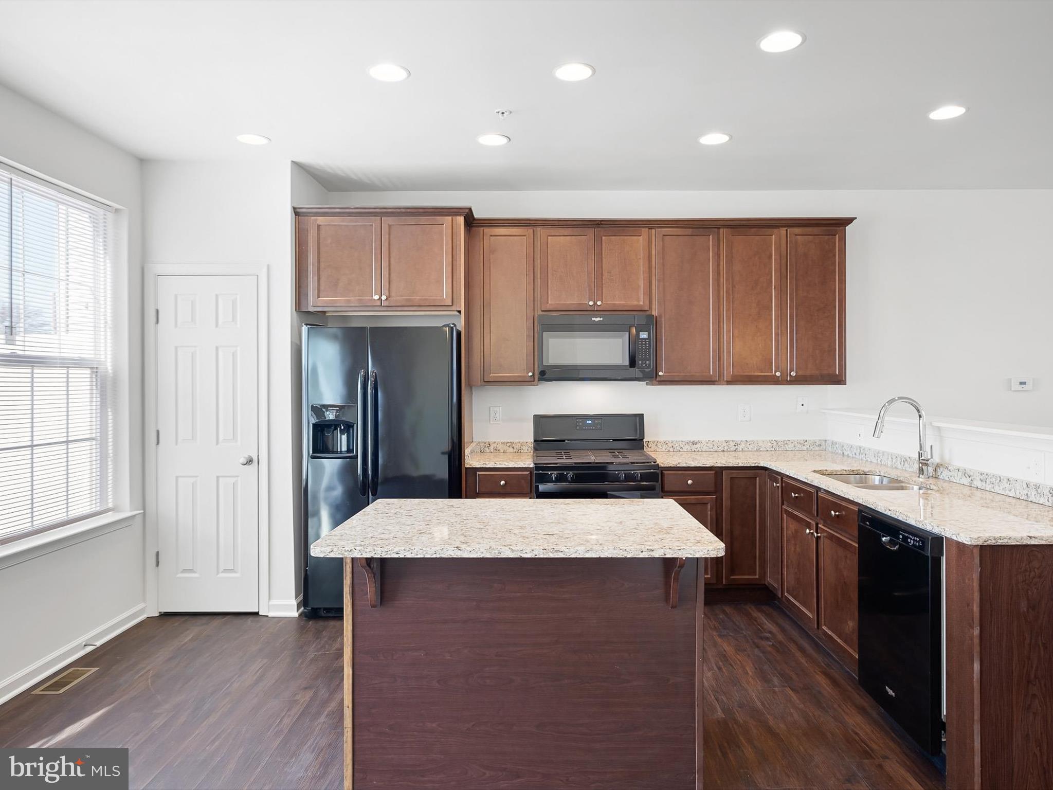 415 Lenape Way Claymont, DE 19703 - Photo 10 of 26 a kitchen with kitchen island granite countertop a sink stove and refrigerator