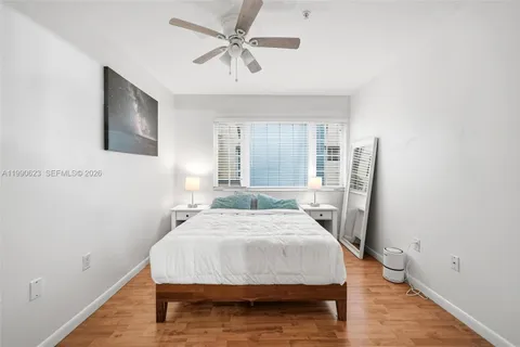 a bed sitting in a spacious bedroom next to a window