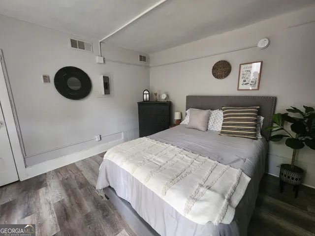 a bedroom with a bed and painting on the wall