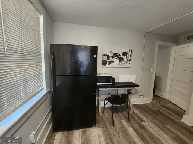 a view of a refrigerator in kitchen and dining room with wooden floor
