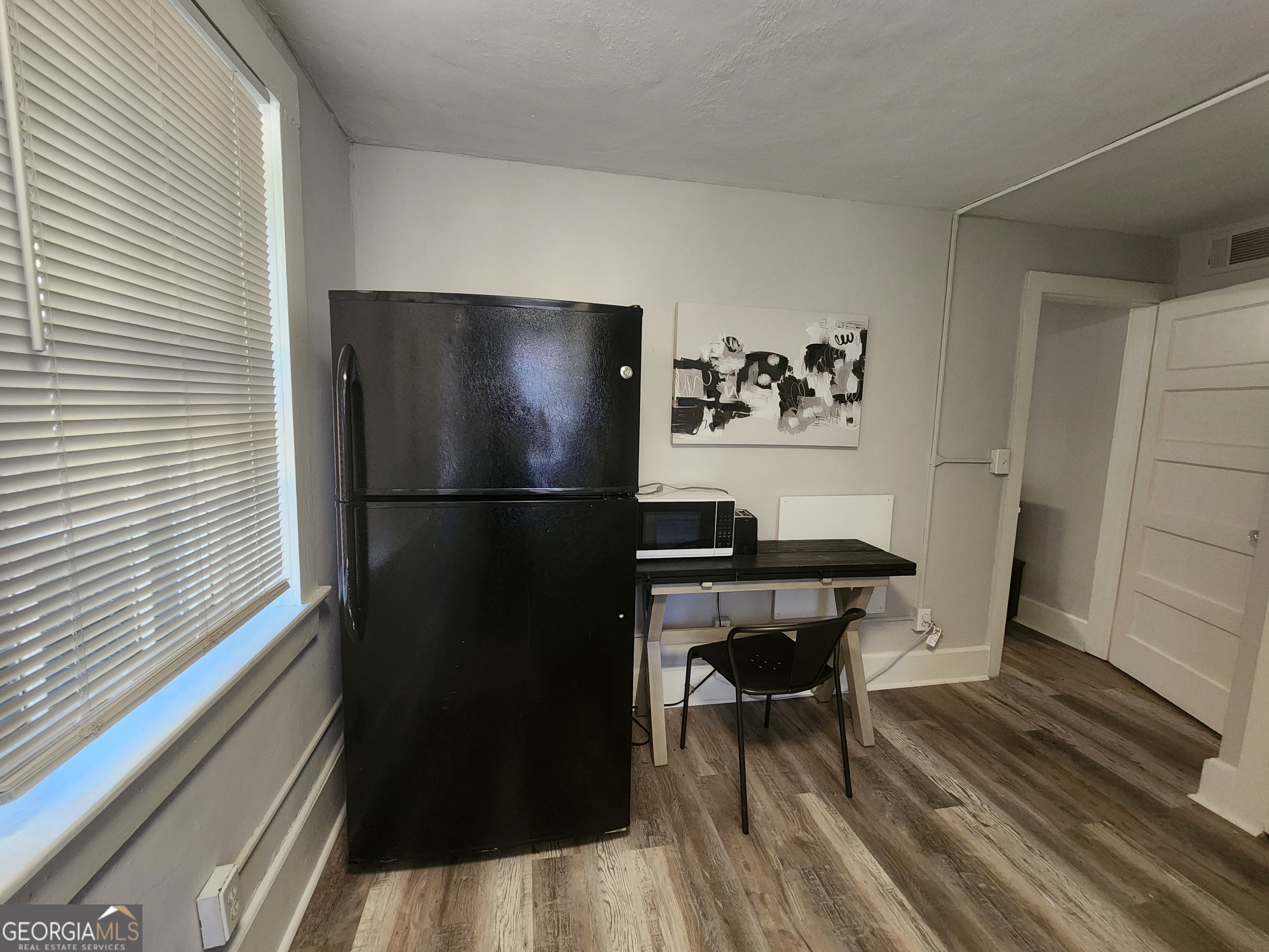 917 Oakview Avenue, Unit 6 Columbus, GA 31906 - Photo 7 of 13 a view of a refrigerator in kitchen and dining room with wooden floor