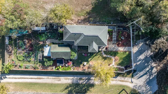 an aerial view of a house with swimming pool and garden