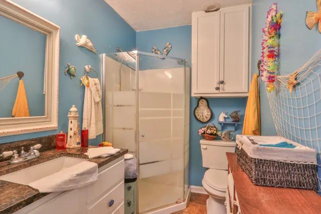 a bathroom with a granite countertop toilet sink and mirror
