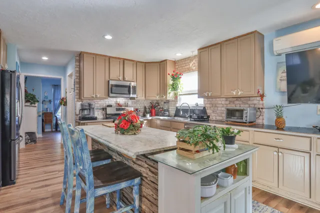 a kitchen with granite countertop white cabinets and stainless steel appliances