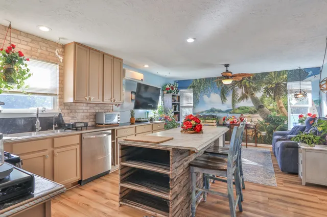 a kitchen with granite countertop a sink white cabinets and wooden floor