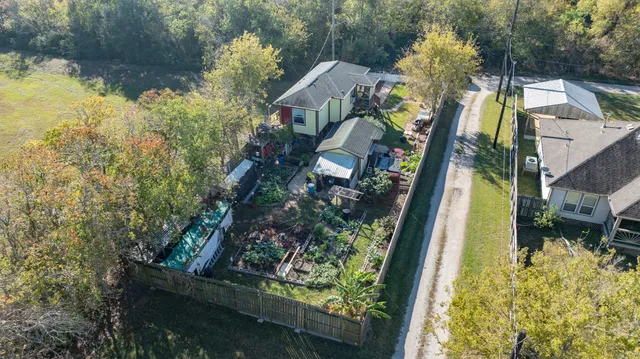 a aerial view of a house with swimming pool and large trees