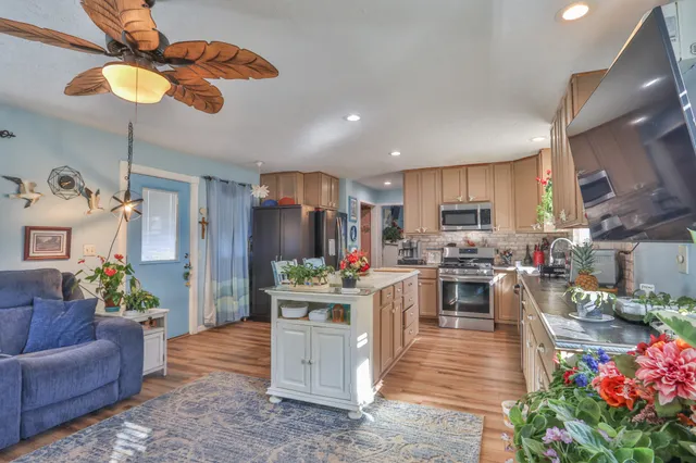 a living room with stainless steel appliances kitchen island furniture and a view of kitchen