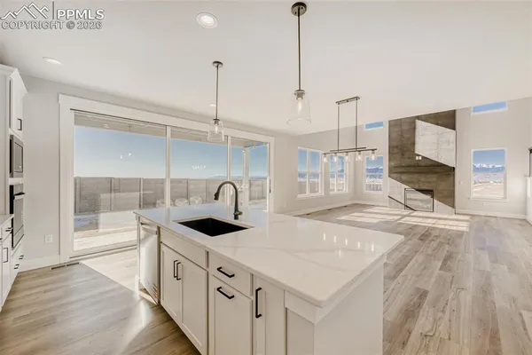 a kitchen with stainless steel appliances granite countertop a sink a oven a stove and a wooden floor