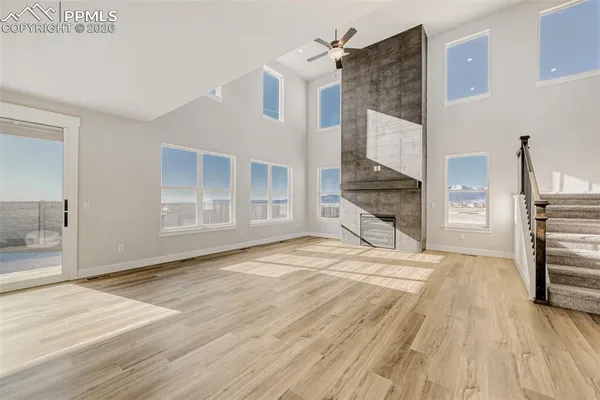 a view of a livingroom with wooden floor and kitchen view