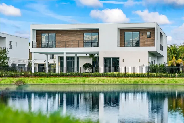 a front view of a house with a yard and a large tree