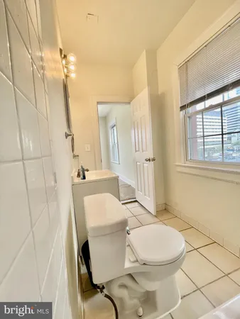 a bathroom with a sink a toilet a mirror and shower