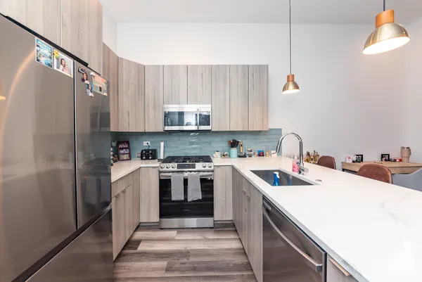 a kitchen with a white cabinets a sink a stove and a refrigerator
