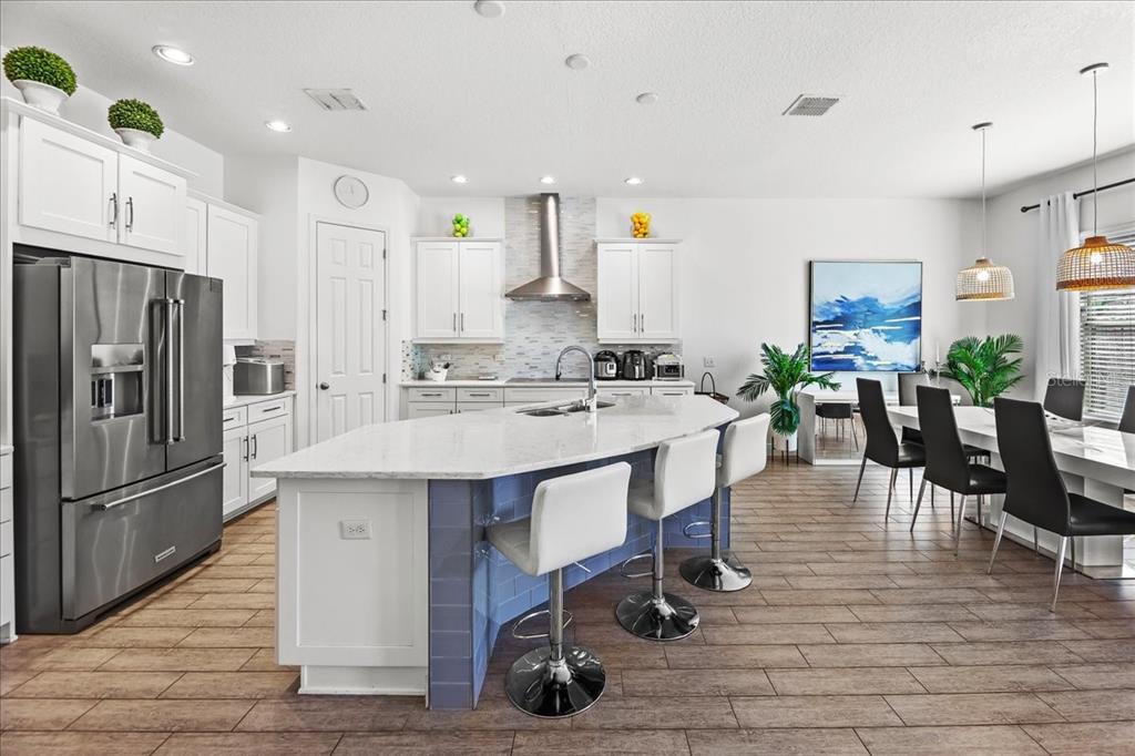 8746 Crescendo Avenue Windermere, FL 34786 - Photo 12 of 56 a kitchen with stainless steel appliances a table chairs refrigerator and sink