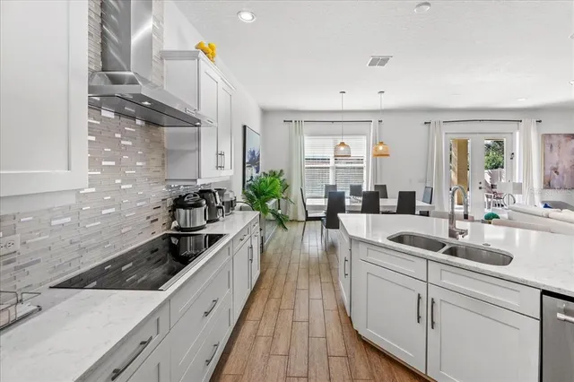 a large kitchen with cabinets a sink a stove and wooden floor