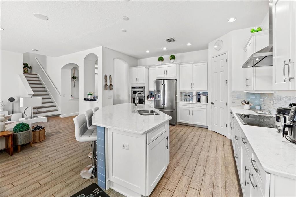 8746 Crescendo Avenue Windermere, FL 34786 - Photo 16 of 56 a large kitchen with cabinets a sink a stove and wooden floor