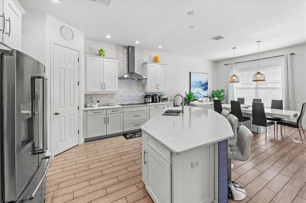 8746 Crescendo Avenue Windermere, FL 34786 - Photo 7 of 56 a kitchen with stainless steel appliances kitchen island granite countertop a sink refrigerator and cabinets
