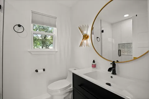 a bathroom with a sink a toilet and a mirror