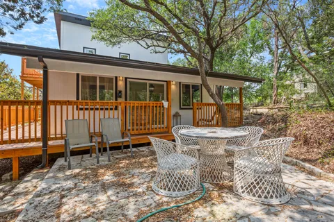 a view of a house with backyard and sitting area