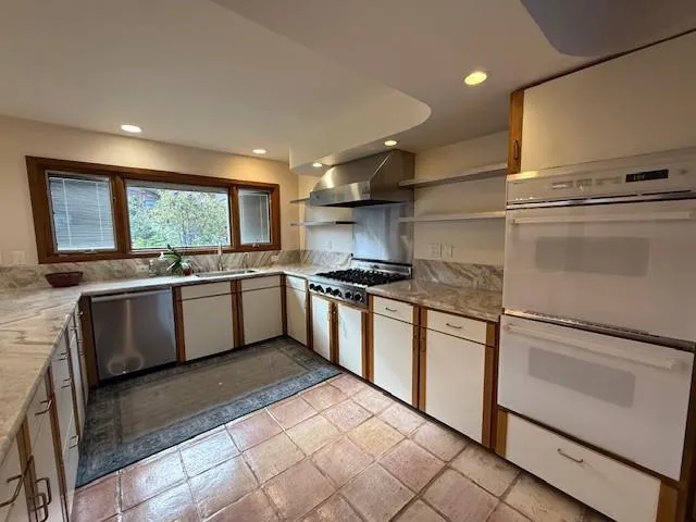 a kitchen with stainless steel appliances granite countertop a stove a sink and a refrigerator