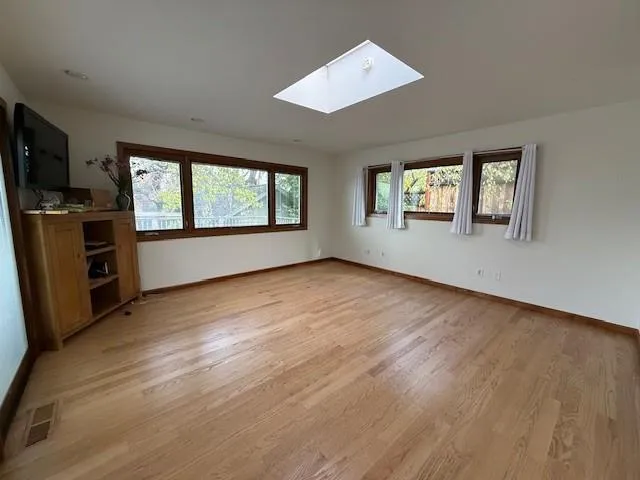 an empty room with wooden floor and a fireplace