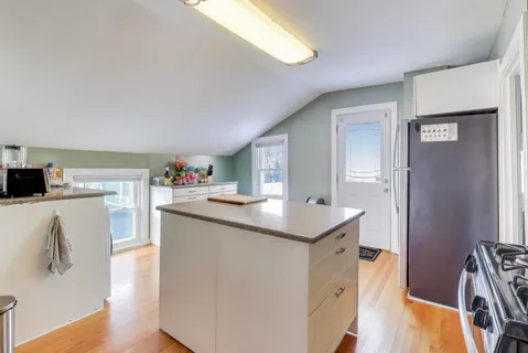 a kitchen with granite countertop a sink stove and wooden floor