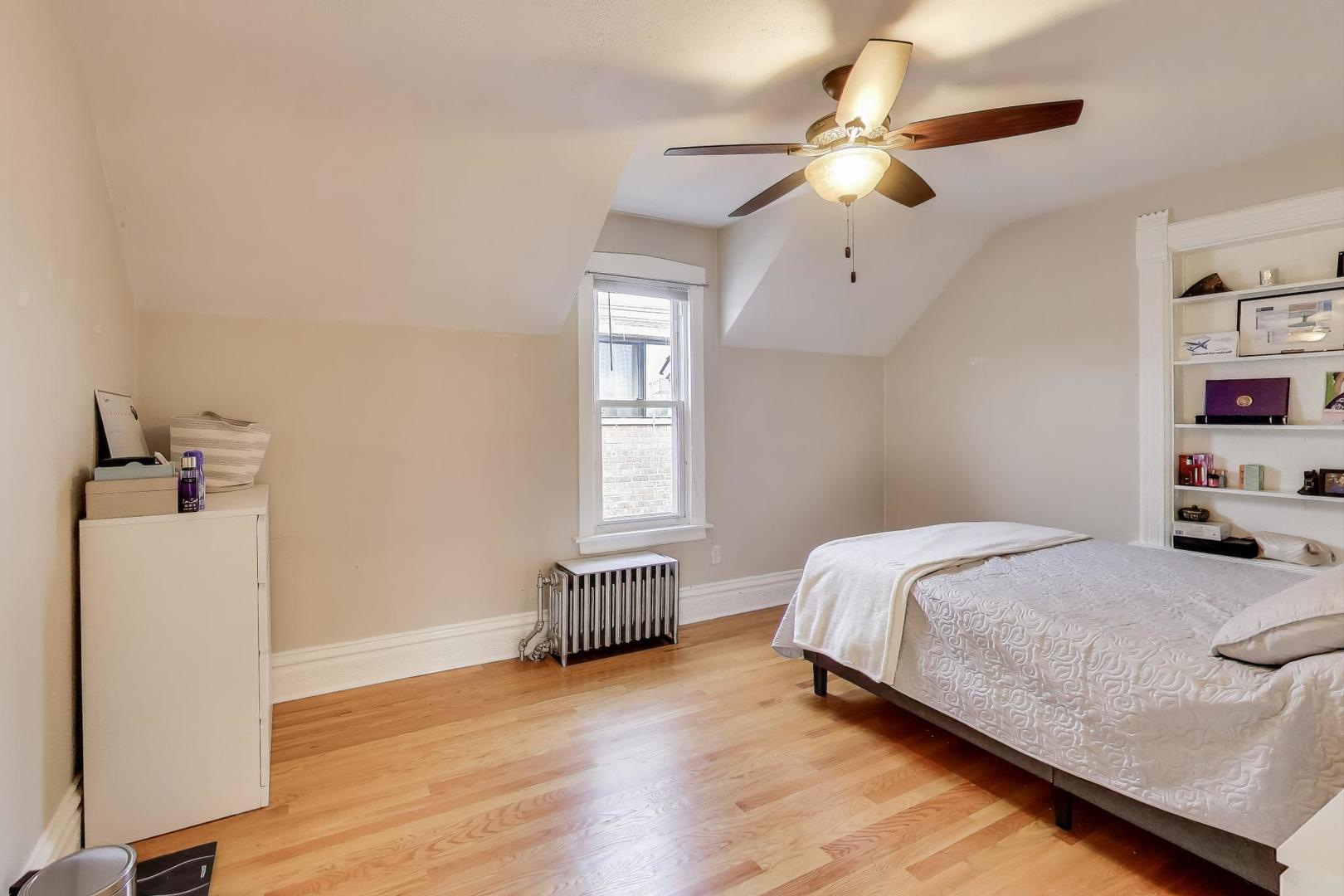 7330 North Honore Street Chicago, IL 60626 - Photo 26 of 43 a bedroom with a bed and wooden floor