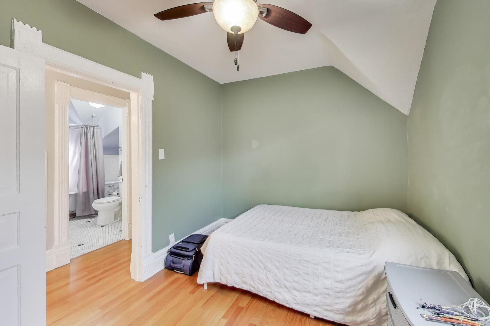 7330 North Honore Street Chicago, IL 60626 - Photo 27 of 43 a bedroom with a bed and a chandelier