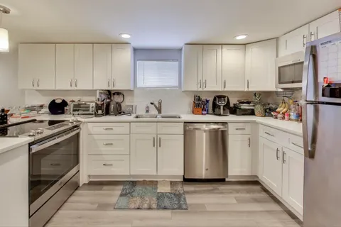 a kitchen with white cabinets sink and white appliances