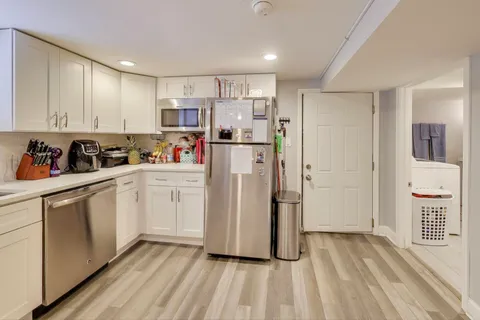 a kitchen with a refrigerator a sink and cabinets
