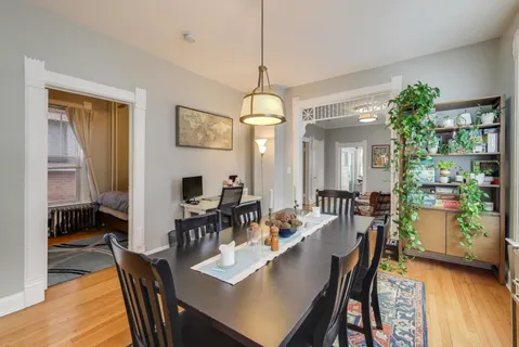 a view of a a dining room with furniture window and wooden floor