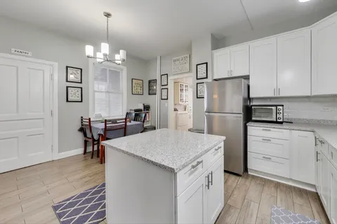 a kitchen with refrigerator cabinets and wooden floor